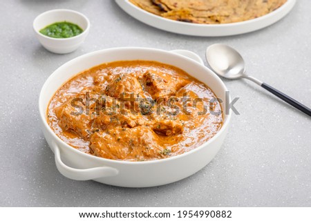 butter chicken, an Indian creamy chicken gravy served in a white bowl with roti or naan Royalty-Free Stock Photo #1954990882