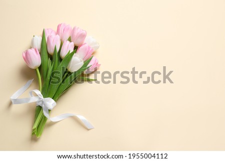 Beautiful pink spring tulips on beige background, top view. Space for text