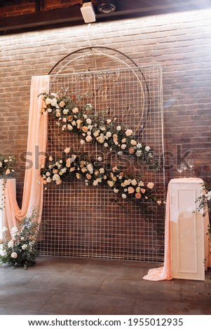 Wedding decor. Photographic area is a stylish wedding decoration. Decorated with flowers, mini florals. Wedding photo zone with flowers. Hand made wedding decorations. Place for taking pictures.