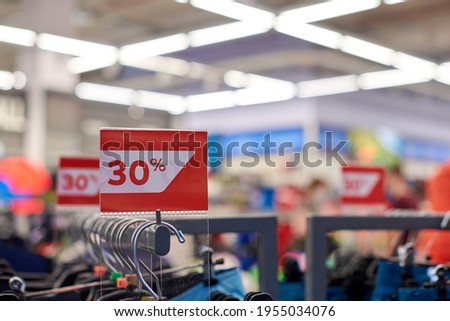 Seasonal sale 30% off, holiday discounts in shopping mall, Black Friday. New Year's sale time at european shopping center. Christmas promotions in clothing store. Sportswear and clothes.
