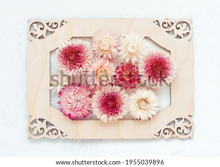 Retro rustic wedding invitation with floral pattern on wooden frame on white background. Flat lay flowers design. Spring decoration backdrop. Autumn composition bouquet.