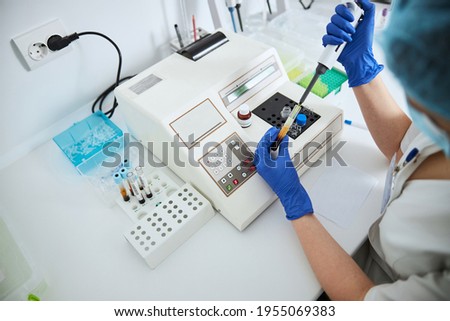 Lab worker conducting a coagulation test using an automated pipette Royalty-Free Stock Photo #1955069383