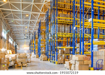 Interior of a modern warehouse storage with rows and goods boxes on high shelves Royalty-Free Stock Photo #1955072119