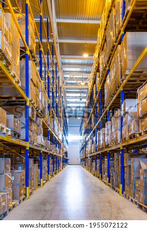 Interior of a modern warehouse storage with rows and goods boxes on high shelves Royalty-Free Stock Photo #1955072122
