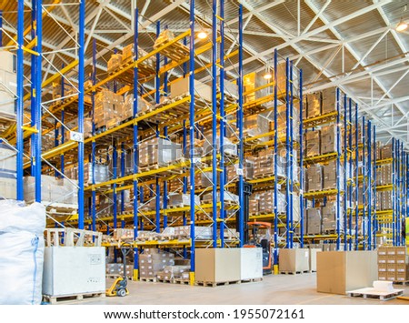 Interior of a modern warehouse storage with rows and goods boxes on high shelves Royalty-Free Stock Photo #1955072161