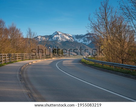 German highway driveway on Sunday sunny day with Alps mountains in background.