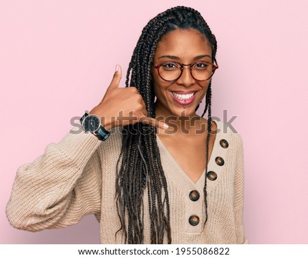 African american woman wearing casual clothes smiling doing phone gesture with hand and fingers like talking on the telephone. communicating concepts. 
