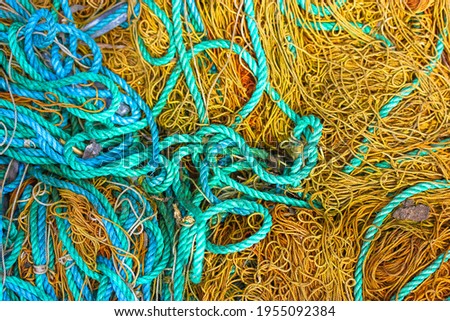 Various rough ropes scattered in a chaotic order, view from above. Brown and blue ropes from above. Navy texture. Maritime ropes texture close-up. Safety rope texture. 