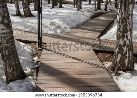 A walkway made of wooden flooring in a city park.