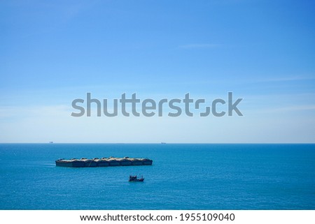 Blue sea and summer sky with sand barge and little boat at Si chang island, Chonburi, Thailand. Calming seascape and beautiful ocean for background.