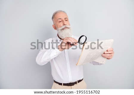 Photo of handsome strict grey hair old man teacher read magazine wear white shirt isolated on grey color background