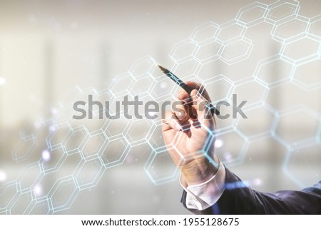 Man hand with pen draws abstract virtual wireless technology hologram with hexagon on blurred office background, artificial intelligence and machine learning concept. Multi exposure