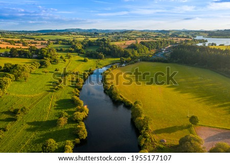 Carrigadrohid Cork Ireland, amazing aerial scenery view on old Irish touristic landmark and meadow and river at sunset  Royalty-Free Stock Photo #1955177107