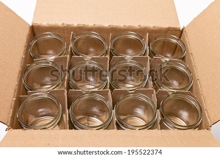 A cardboard box of clean, empty glass jars  with no lids.