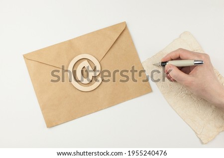 Woman's hand with ballpoint pen writing on vintage paper letter envelope, happy birthday congratulation card, personal note or invitation, Christmas, Easter and New Year greetings. 