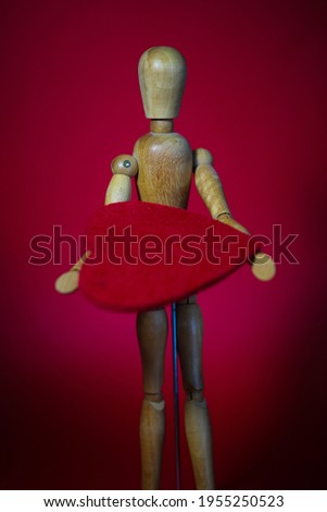 Wooden figure with a heart in hand, Art