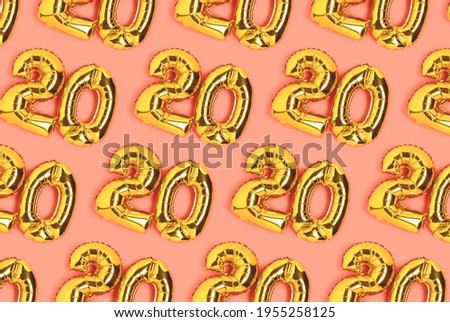 Numbers 20 golden balloons pattern. Twenty years anniversary celebration layout on a coral background. Royalty-Free Stock Photo #1955258125