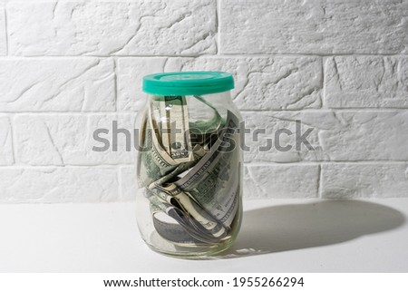 Glass jar full of the American banknotes
