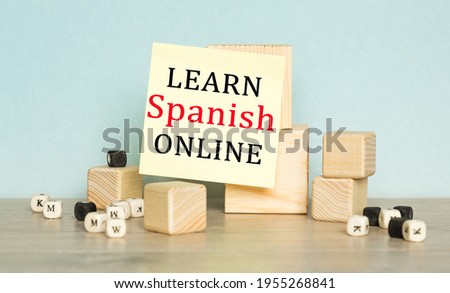 the words LEARN SPANISH ONLINE is written on the sticker , a wooden cubes structure. Can be used for business, inancial concept. Selective focus.