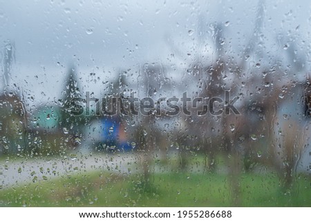 Raindrops on the glass. The background is a blurry image of the street. Close-up