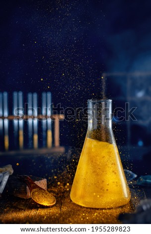 gold liquid in a chemical flask. Science, chemistry Royalty-Free Stock Photo #1955289823