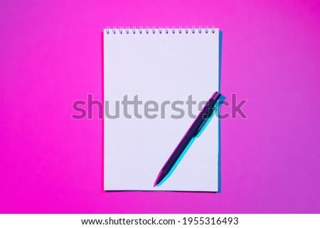 Blank notebook with copy space and pen on pink background. Double colorful shadows