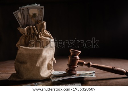 Dollar money bag and judge's gavel Royalty-Free Stock Photo #1955320609