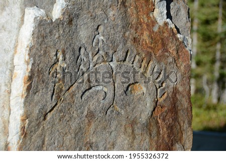 stone carved depictions of men standing on a whale in National Park Mount Revelstoke