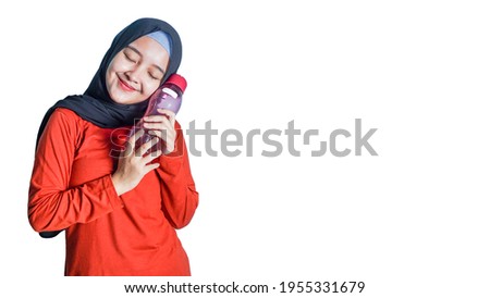 asian woman with hijab holding a water bottle.