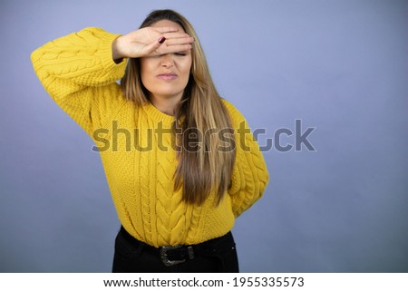 Young beautiful blonde woman with long hair wearing a yellow sweater Touching forehead for illness and fever, flu and cold, virus sick