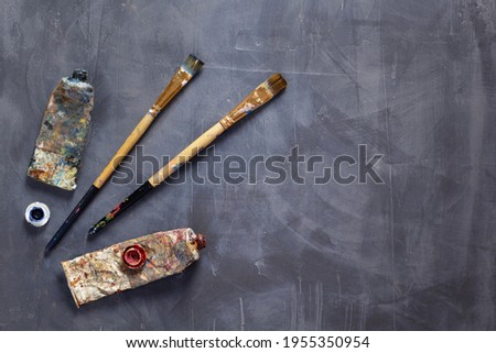 Used paintbrush and tubes as painter tools at table background texture. Art painter concept and paint brush