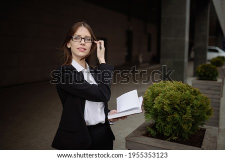 A businesswoman with glasses makes a note in a notebook.Management concept.