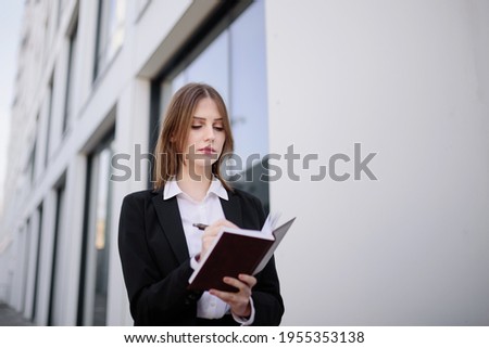 A businesswoman makes a note in a notebook