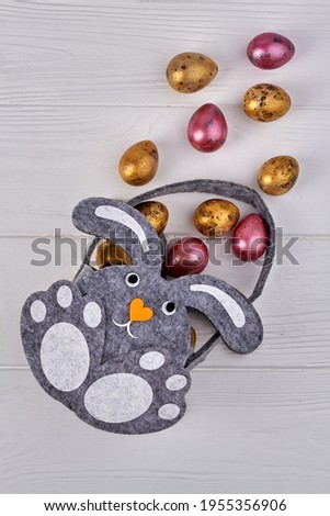 Vertical shot cartoon bunny image and colored eggs.
