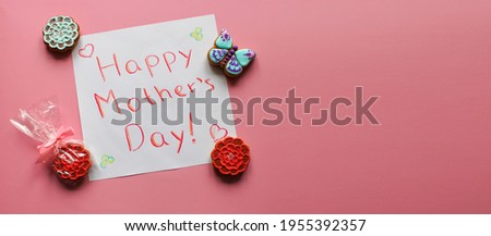 Greeting card Happy Mother's day with small handmade gingerbreads in the shape of flowers and butterfly as a gifts for mom. Pink background