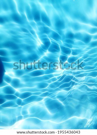 Reflection​ on​ surface​ blue​ water​ in​ the​ sea. Abstract​ of​ surface​ blue​ water​ for​ background. Closeup​ abstract​ of​ surface​ blue​ water. Splash​ed​ water​ in the​ swimming​pool.