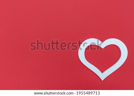Red paper background with space for text and white heart
