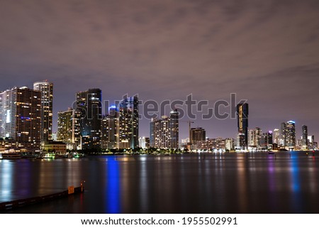 Miami Florida, sunset panorama with colorful illuminated business and residential buildings and bridge on Biscayne Bay. Miami night