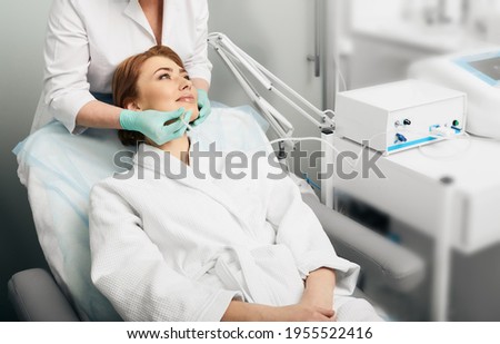 Facial ozone therapy. Woman during rejuvenation skin face with ozone therapy procedure Royalty-Free Stock Photo #1955522416