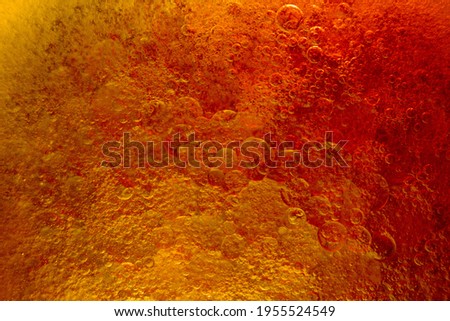 Abstract background with oil droplets on water surface red and yellow