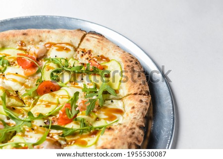 Pizza with rucola and cherry tomatoes over white. Italian cuisine concept, traditional pizza recipe.