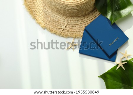 Passports and summer accessories on white background, space for text