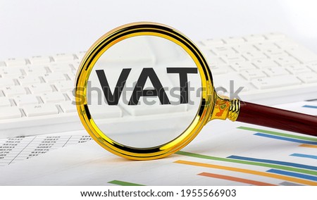 Magnifying glass with the word VAT on chart background