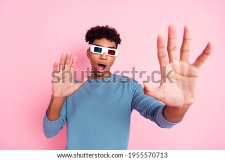 Photo portrait of young guy watching film in cinema wearing 3d glasses eating pop corn smiling isolated on pastel pink color background
