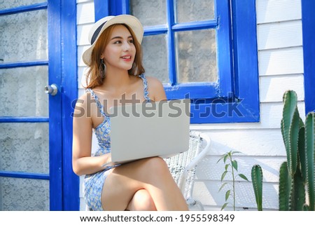 Asian woman playing or working with laptop