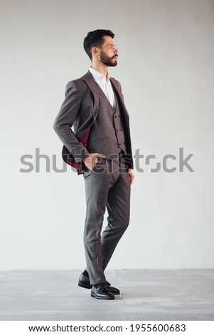 Full length photo of young stylish businessman that is in suit indoors. Conception of success.