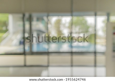 empty living room interior with large window and swimming pool blurred background