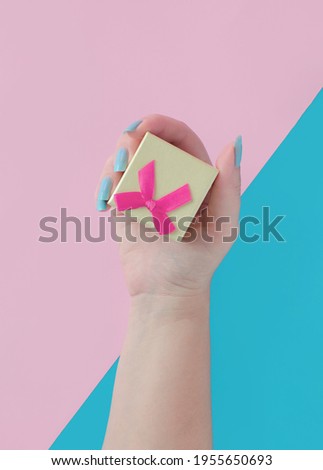 Close-up shot of female hands holding a gift box. Shallow depth of field with focus on a small box.