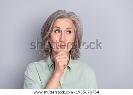 Photo of thoughtful minded serious mature woman look copyspace thinking dreaming isolated on grey color background
