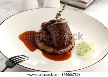 Beef tenderloin with sauce and potato rosti on white background 